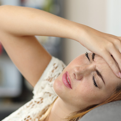 Woman experiencing headache and fatigue
