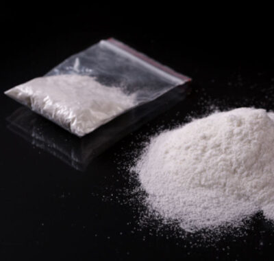 cocaine powder on a flat surface and in a plastic bag