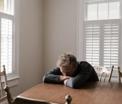 depressed man, leaning over a table