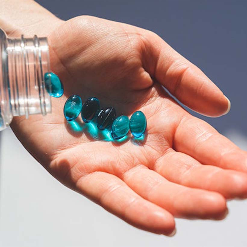 Hand holding blue pills