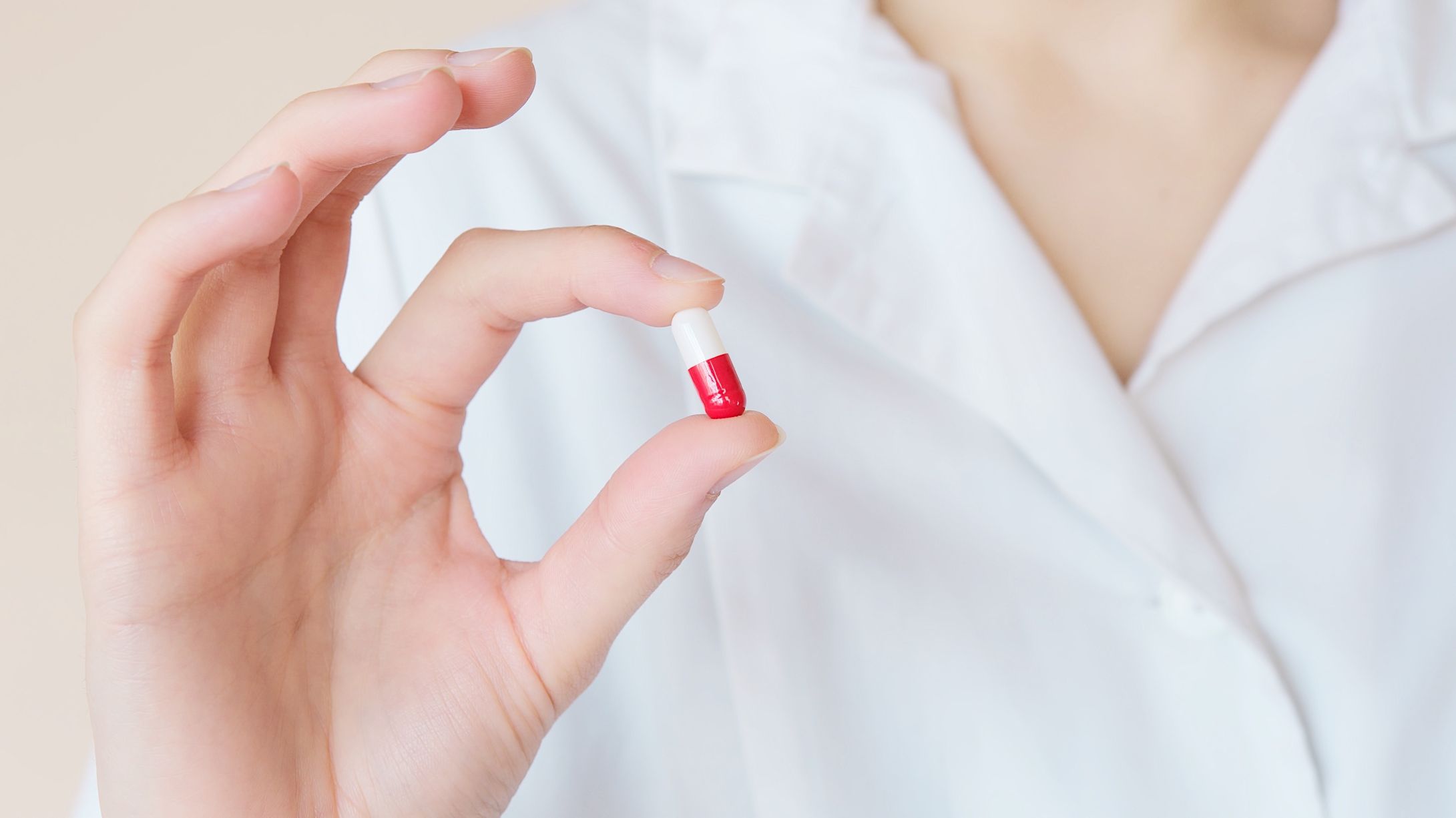 nurse holding a red and white pill