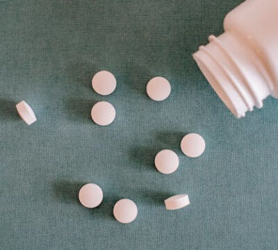 pink pills spilling out of a pink bottle