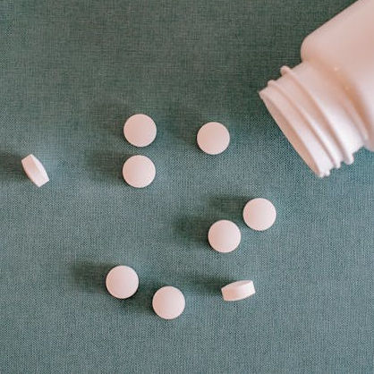 pink pills spilling out of a pink bottle