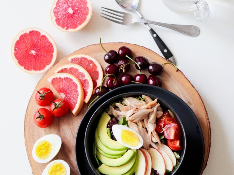 A vibrant bowl of salad featuring eggs, grapefruit, and a variety of fresh fruits, showcasing a colorful and healthy meal. Fiber rich diet.