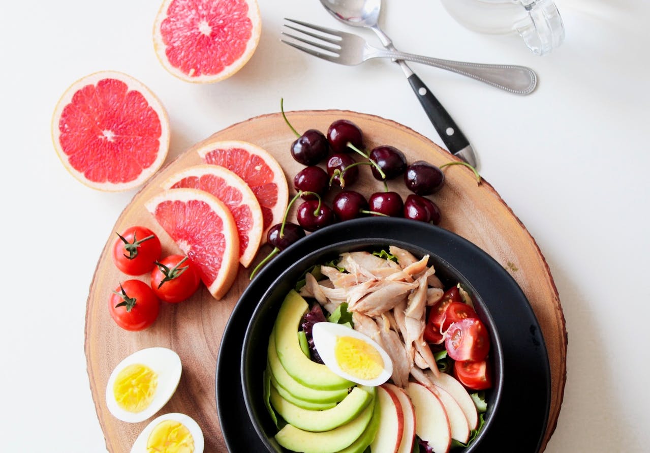 A vibrant bowl of salad featuring eggs, grapefruit, and a variety of fresh fruits, showcasing a colorful and healthy meal. Fiber rich diet.