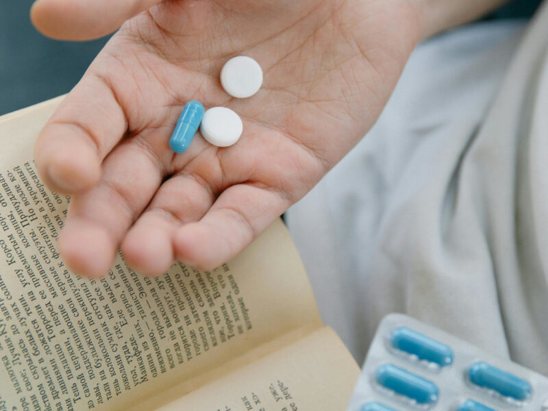 student with book in one hand and drugs in the other