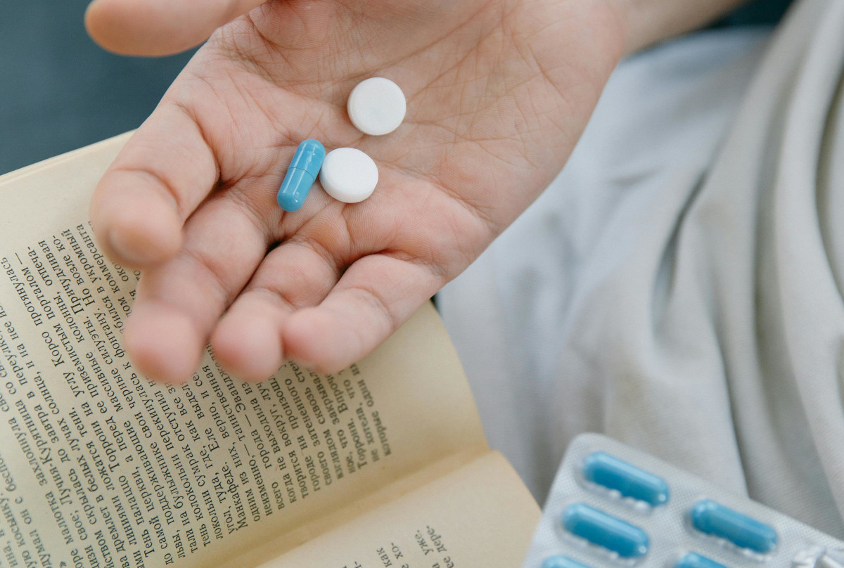 student with book in one hand and drugs in the other