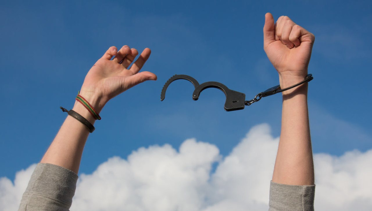 man with broken handcuffs and hands in the air