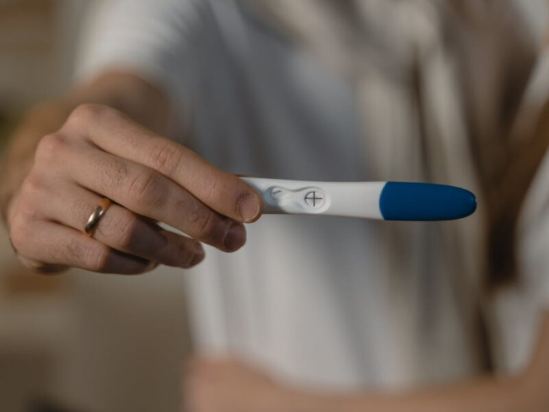 man holding a positive pregnancy test