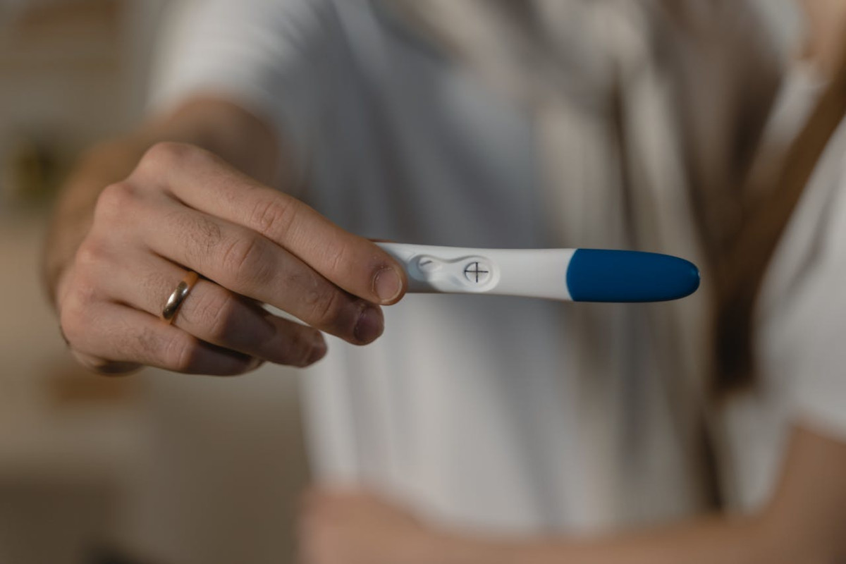 man holding a positive pregnancy test