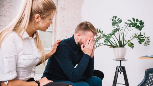psychologist consoling her male depressed patient