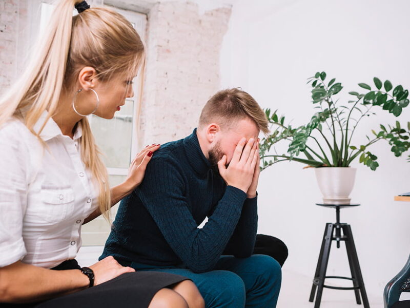 psychologist consoling her male depressed patient