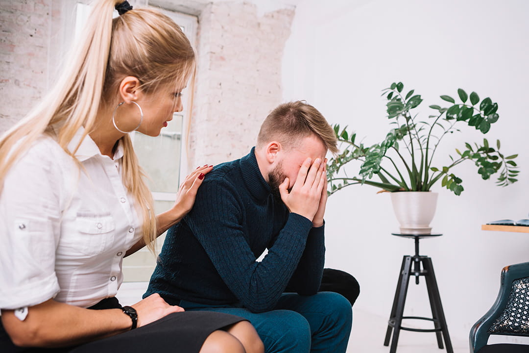 psychologist consoling her male depressed patient