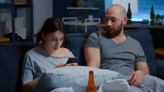 man and woman sitting on a couch