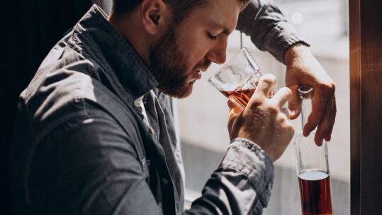 Man drinker depressed with bottle of whiskey